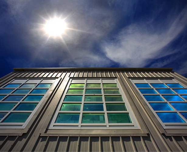 Custom window installation reflecting the sun and sky. Energy-efficient design.