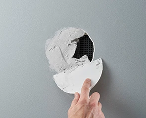 Applying a patch to a hole in the wall. Hole patching project in progress.