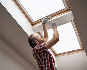 Man repairing a skylight with a screwdriver. Skylight repair.